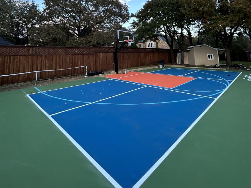 A tennis court with two different colors of blue and orange.