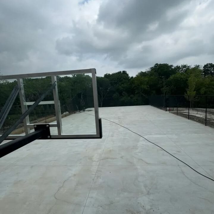 A concrete walkway with trees in the background.